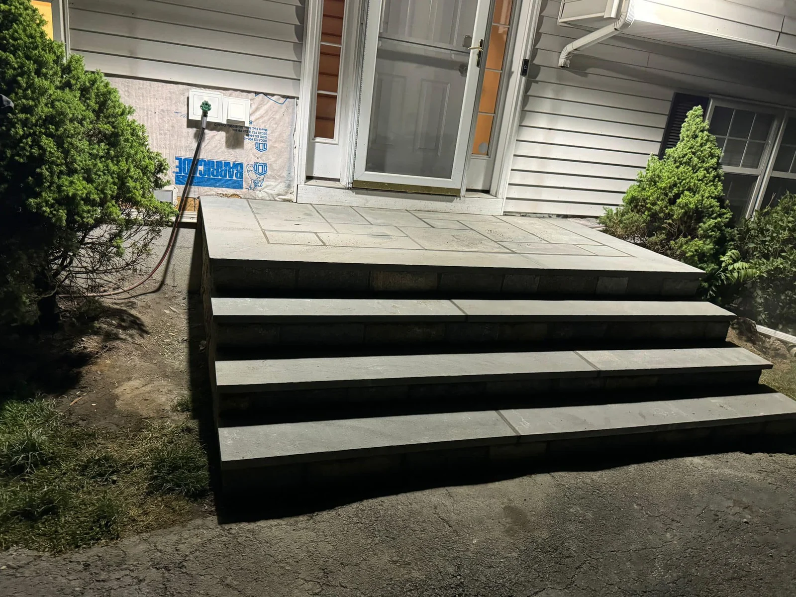 Custom bluestone front entry steps and landing by Eight Lanes Landscaping